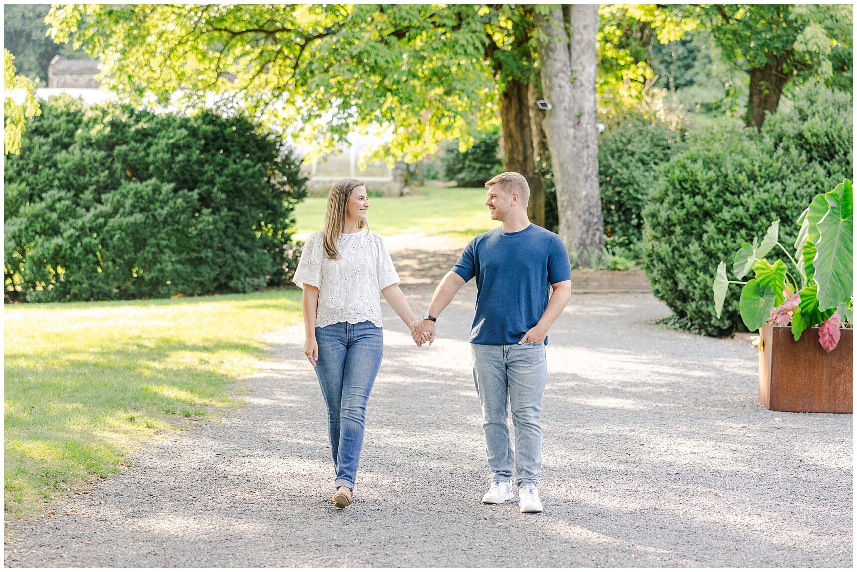 Sarah and Ian walking through the gardens during their summer engagement session at Morven Park